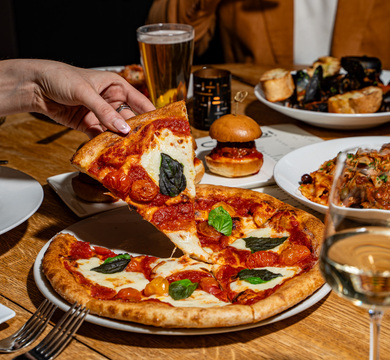 Person taking a pizza slice.